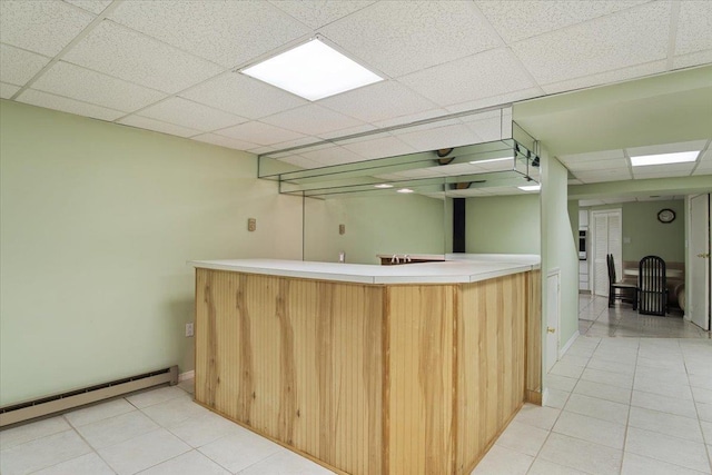 29 Sunset Rd S, Albertson, NY 11507 - kitchen with baseboard heating, light tile patterned floors, a paneled ceiling, and light countertops