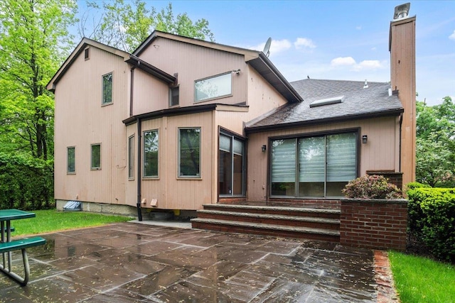 29 Sunset Rd S, Albertson, NY 11507 - back of house featuring entry steps, a chimney, and a patio