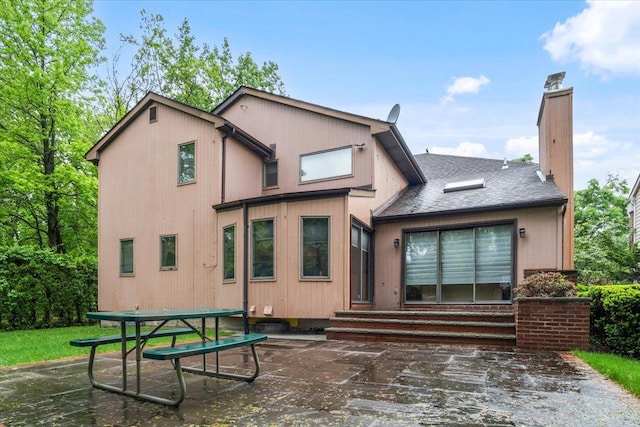 29 Sunset Rd S, Albertson, NY 11507 - rear view of house featuring entry steps, a chimney, a patio, and a shingled roof