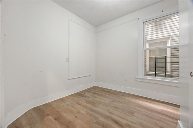 unfurnished room featuring light wood finished floors and baseboards