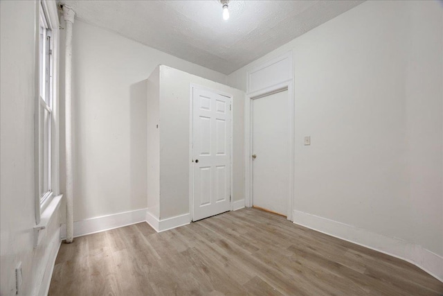 spare room featuring wood finished floors and baseboards