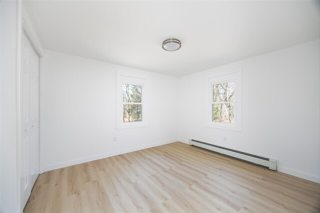 3 Holt Rd, Red Hook, NY 12571 - unfurnished bedroom with a baseboard heating unit, multiple windows, wood finished floors, and a closet