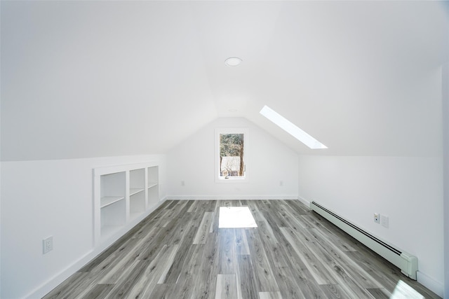 3 Holt Rd, Red Hook, NY 12571 - additional living space with a baseboard radiator, a skylight, built in features, wood finished floors, and vaulted ceiling