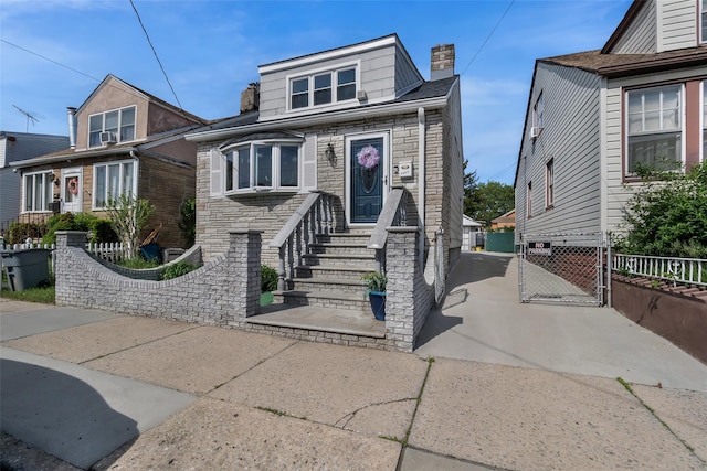 1257 E 87th St, Brooklyn, NY 11236 - view of front of property featuring stone siding, fence, a chimney, and a gate