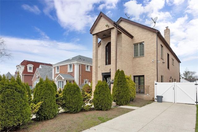 186-31 Radnor Rd, Jamaica Estates, NY 11432 - view of property exterior with a gate, brick siding, a chimney, and fence