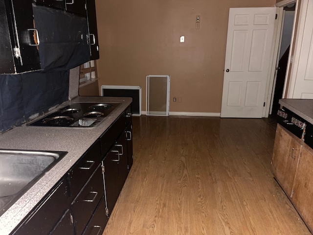 7 Beaver Dr, Locust Valley, NY 11560 - kitchen featuring wood finished floors, cooktop, baseboards, and a sink
