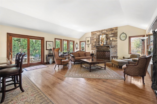 24 Brushwood Ct, East Islip, NY 11730 - living room featuring lofted ceiling, wood finished floors, and a stone fireplace