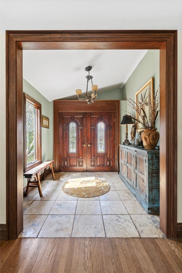 24 Brushwood Ct, East Islip, NY 11730 - foyer entrance featuring lofted ceiling, a chandelier, stone tile flooring, and ornamental molding