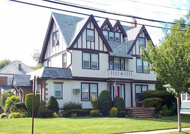 33-82 159th St, Flushing, NY 11358 - tudor house featuring stucco siding, a front yard, and an AC wall unit