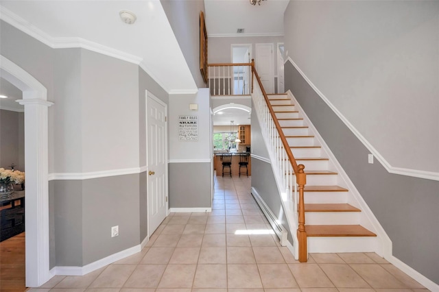 7 Ellbridge Ct, South Setauket, NY 11720 - stairway featuring arched walkways, a baseboard radiator, tile patterned flooring, and baseboards