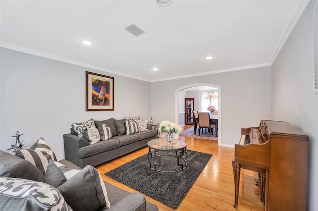 7 Ellbridge Ct, South Setauket, NY 11720 - living area with arched walkways, light wood-style flooring, a chandelier, ornamental molding, and recessed lighting