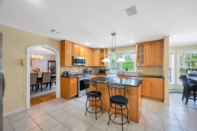 7 Ellbridge Ct, South Setauket, NY 11720 - kitchen with stainless steel appliances, a breakfast bar, a kitchen island, light tile patterned floors, and recessed lighting
