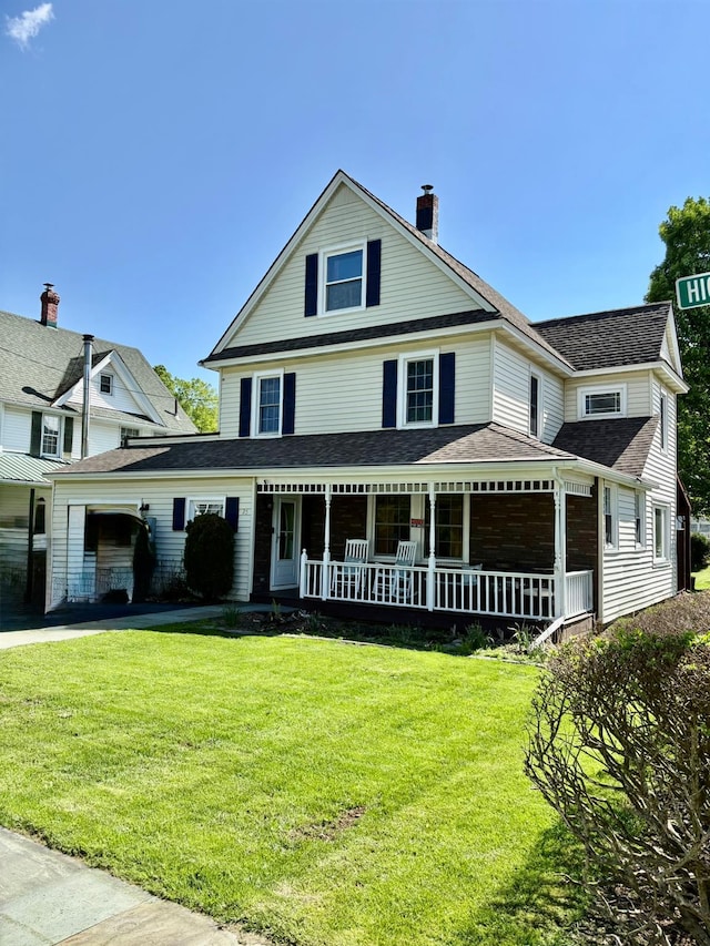 view of front of house with a porch, a chimney, a front yard, and roof with shingles