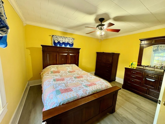 bedroom with light wood-style floors, ornamental molding, ceiling fan, and baseboards
