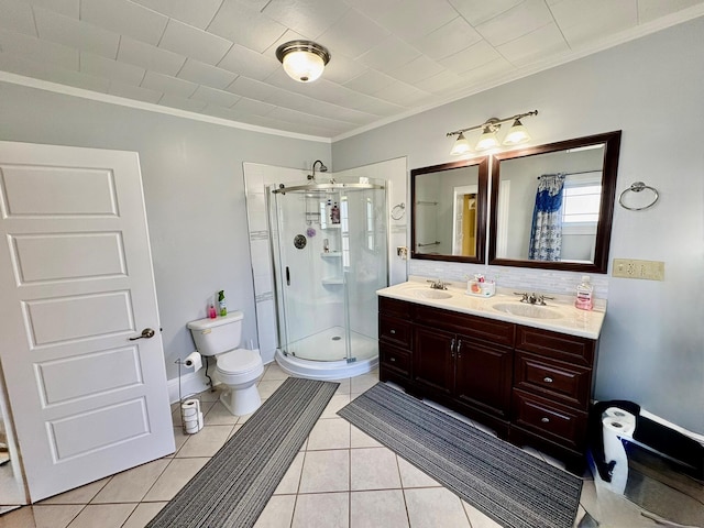 full bath featuring a shower stall, toilet, ornamental molding, double vanity, and tile patterned floors