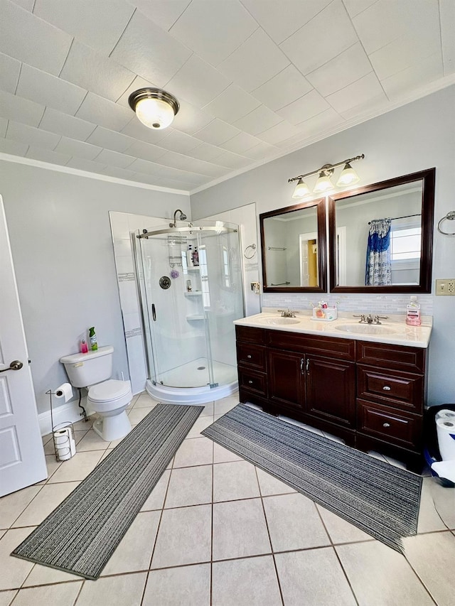 full bath with a stall shower, double vanity, ornamental molding, toilet, and tile patterned flooring