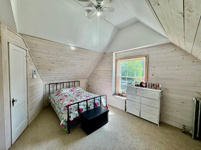 bedroom featuring wood walls, vaulted ceiling, radiator, carpet, and ceiling fan