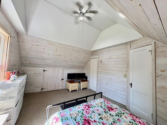 bedroom featuring wooden walls, vaulted ceiling, carpet flooring, and a ceiling fan