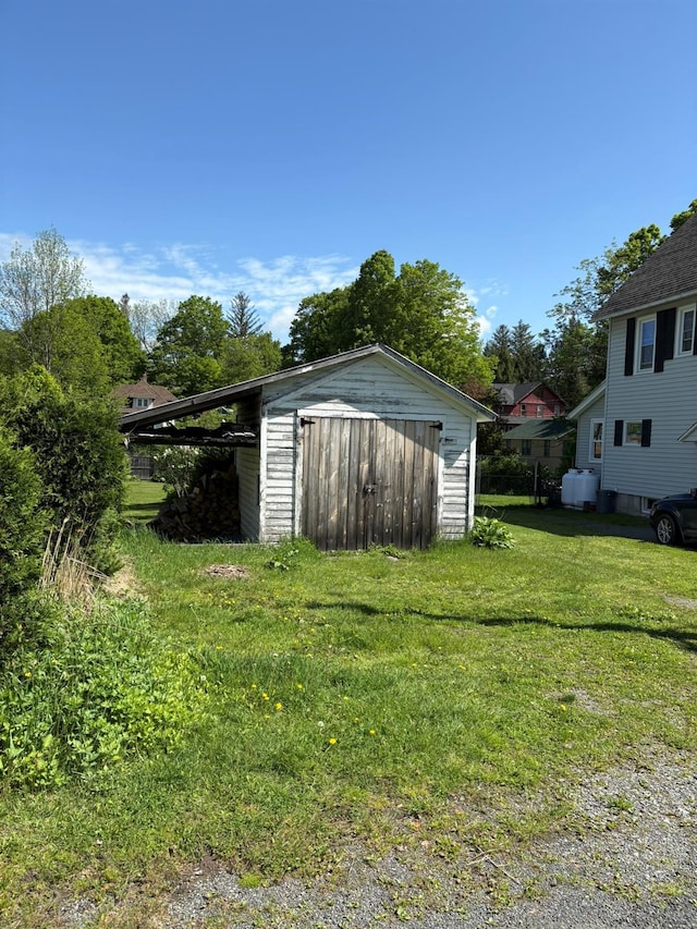 view of green lawn with a storage unit and an outdoor structure