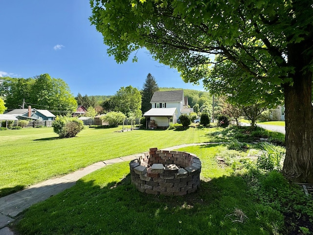 view of green lawn with a fire pit