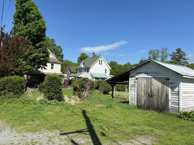 view of green lawn featuring a shed and an outbuilding