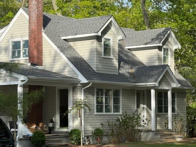 985 Track Ave, Cutchogue, NY 11935 - view of front facade featuring covered porch, a chimney, and roof with shingles