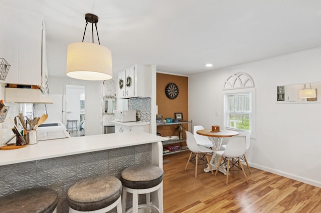 8 N Railroad Ave, Jamesport, NY 11901 - kitchen featuring white appliances, light wood-type flooring, white cabinetry, a peninsula, and light countertops