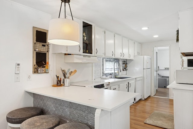 8 N Railroad Ave, Jamesport, NY 11901 - kitchen with a sink, under cabinet range hood, white appliances, light wood-type flooring, and light countertops