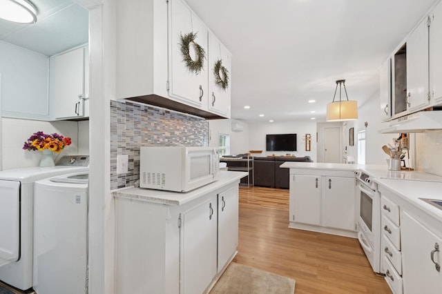 8 N Railroad Ave, Jamesport, NY 11901 - kitchen featuring white appliances, independent washer and dryer, under cabinet range hood, light wood-type flooring, and white cabinetry