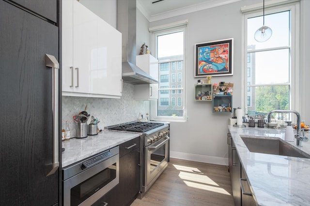 kitchen with stainless steel appliances, a sink, crown molding, white cabinets, and decorative backsplash