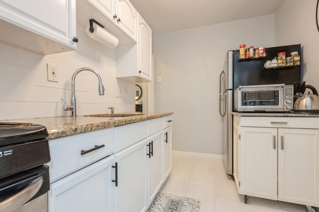 70-08 261th St Unit A1, Glen Oaks, NY 11004 - kitchen with white cabinetry, a sink, light stone counters, and stove
