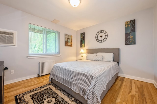 70-08 261th St Unit A1, Glen Oaks, NY 11004 - bedroom featuring radiator, wood finished floors, an AC wall unit, and baseboards