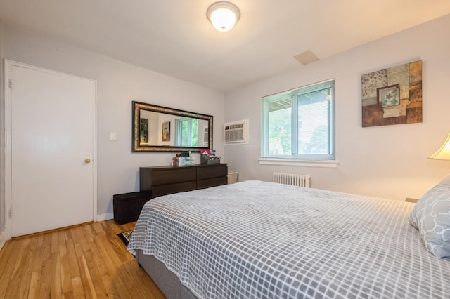 70-08 261th St Unit A1, Glen Oaks, NY 11004 - bedroom featuring radiator heating unit, light wood finished floors, and an AC wall unit