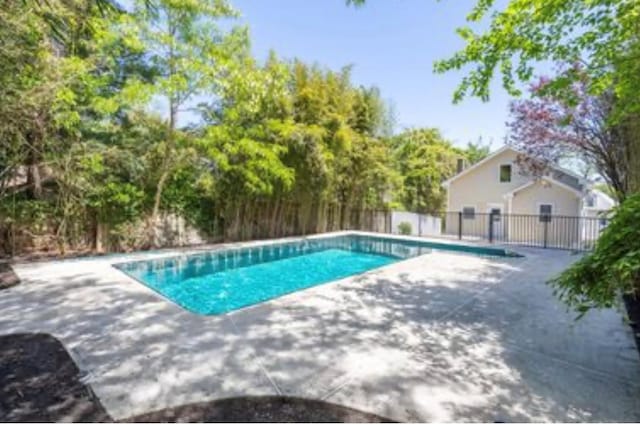 view of swimming pool with a patio and fence