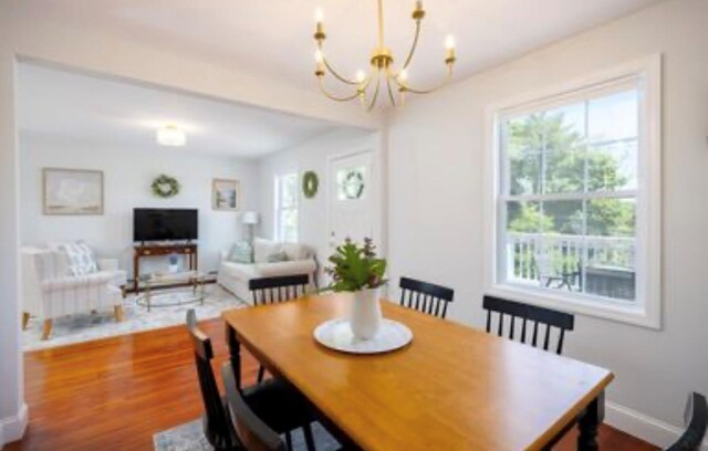 dining room with plenty of natural light, a chandelier, and dark wood-style flooring