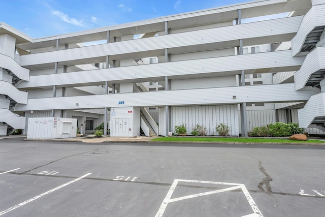 259 Dune Rd Unit 128, Westhampton Beach, NY 11978 - view of building exterior with uncovered parking and stairway