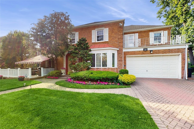 202 Broadway, Lawrence, NY 11559 - colonial house with brick siding, decorative driveway, a balcony, a front yard, and an attached garage