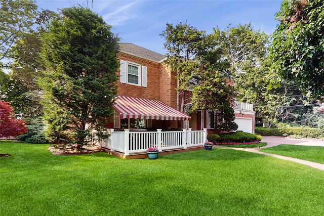 202 Broadway, Lawrence, NY 11559 - view of front of home with brick siding, a front yard, concrete driveway, and a garage