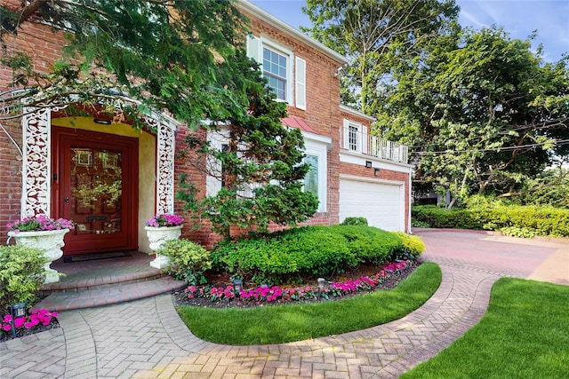 202 Broadway, Lawrence, NY 11559 - entrance to property featuring brick siding, an attached garage, and driveway