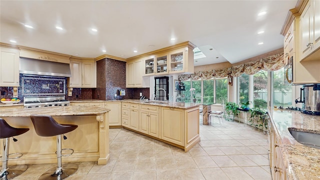 202 Broadway, Lawrence, NY 11559 - kitchen with wall chimney range hood, stove, backsplash, glass insert cabinets, and recessed lighting