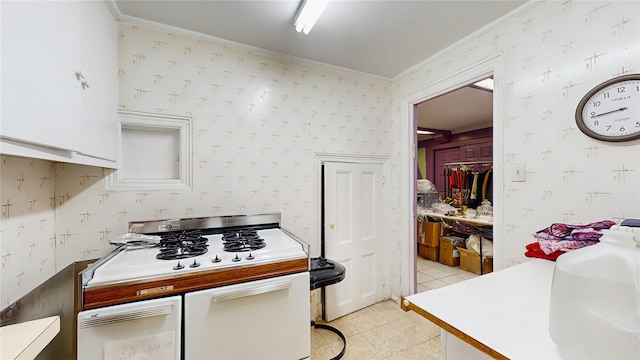202 Broadway, Lawrence, NY 11559 - kitchen featuring wallpapered walls, ornamental molding, light tile patterned floors, range, and white cabinetry