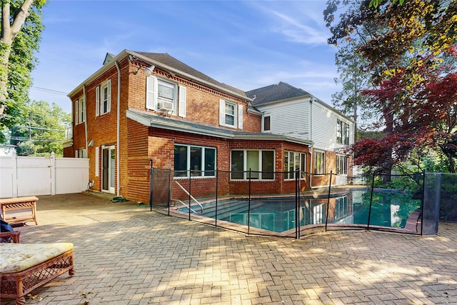 202 Broadway, Lawrence, NY 11559 - rear view of property featuring brick siding, a patio area, a fenced backyard, and a gate