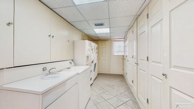 202 Broadway, Lawrence, NY 11559 - laundry room featuring light tile patterned floors, stacked washer / drying machine, and cabinet space