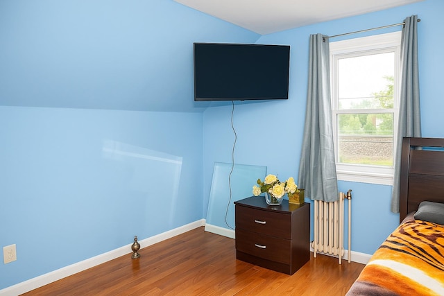 118-37 180th St, Jamaica, NY 11434 - bedroom with radiator heating unit, multiple windows, wood finished floors, baseboards, and lofted ceiling