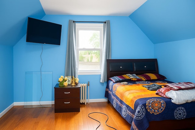 118-37 180th St, Jamaica, NY 11434 - bedroom featuring radiator heating unit, vaulted ceiling, wood finished floors, and baseboards