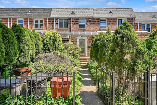 148-35 58th Ave, Flushing, NY 11355 - view of front of property with brick siding, mansard roof, roof with shingles, and fence