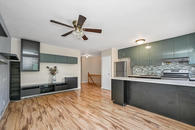 148-35 58th Ave, Flushing, NY 11355 - kitchen featuring stainless steel appliances, light countertops, backsplash, a ceiling fan, and light wood-style flooring