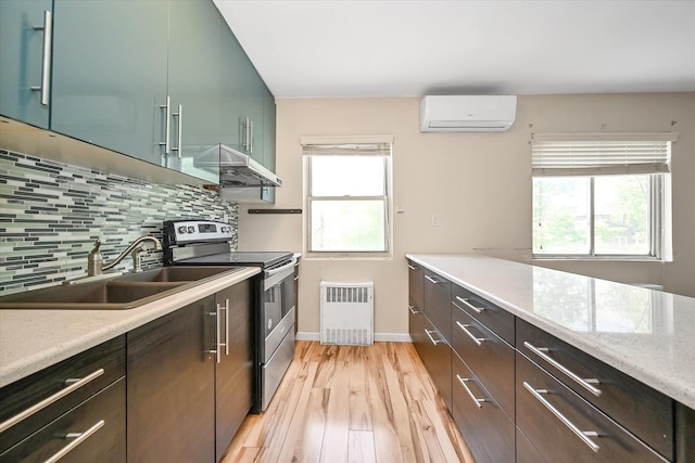 148-35 58th Ave, Flushing, NY 11355 - kitchen featuring stainless steel electric stove, a wall unit AC, a sink, under cabinet range hood, and backsplash