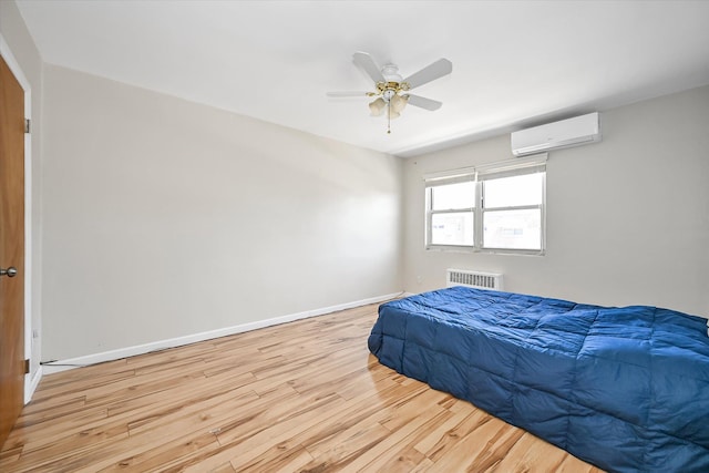148-35 58th Ave, Flushing, NY 11355 - bedroom featuring a wall mounted air conditioner, radiator, wood finished floors, baseboards, and ceiling fan