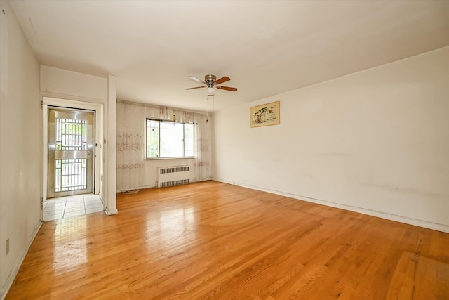 148-35 58th Ave, Flushing, NY 11355 - unfurnished room featuring radiator heating unit, a ceiling fan, light wood-style floors, and baseboards